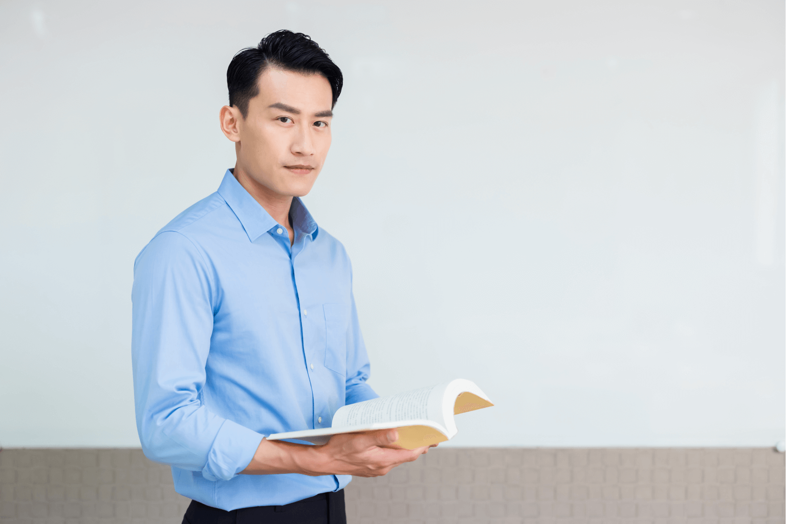 young man holding open book